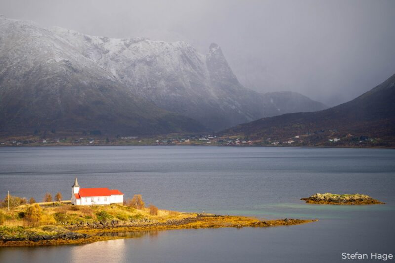 De zon schijnt in het dal van de Lofoten, op het kerkje van Sildpollnes
